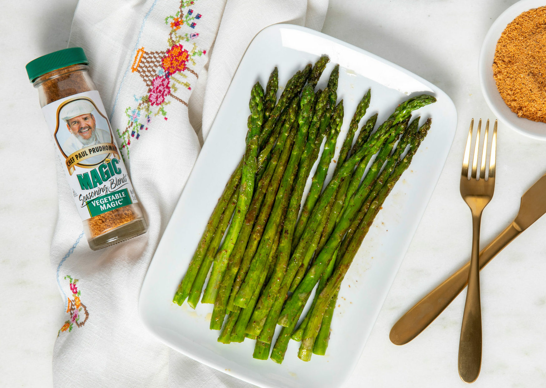 Plate with asparagus, fork, knife and vegetable magic bottle on counter